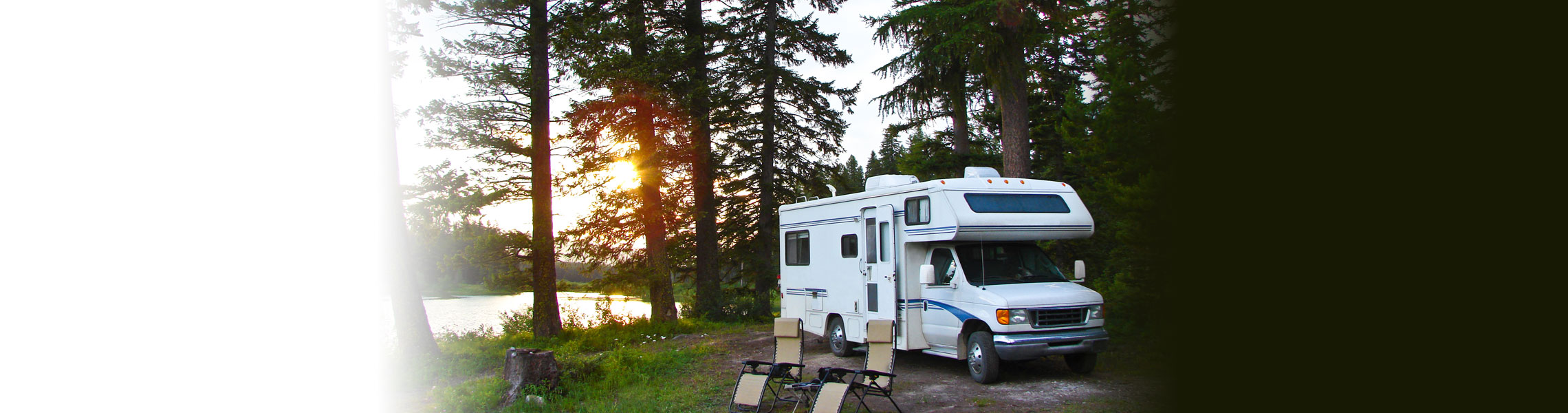 Class C motorhome camped in the pines by a lake